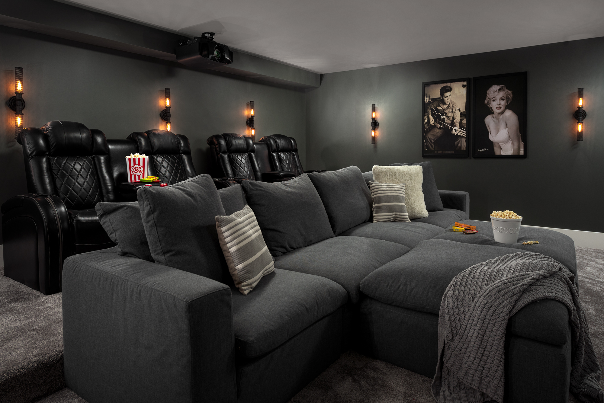 Dark basement theater movie room with gray walls, reclining chairs and sofa. Interior Design by Naperville Interior Designer LC Interiors