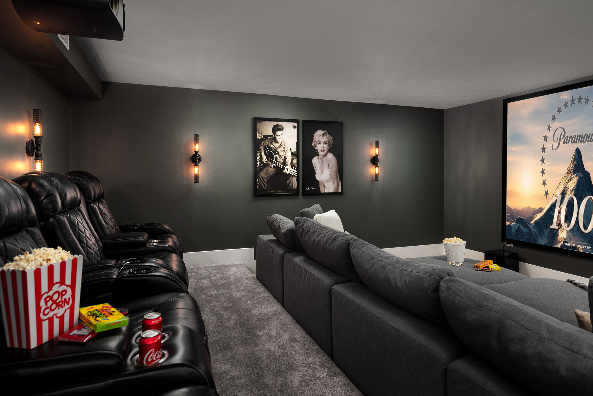 Dark basement theater movie room with gray walls, reclining chairs and sofa. Interior Design by Naperville Interior Designer LC Interiors